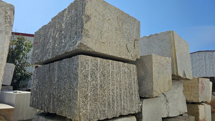 Raw granite blocks stacked in yard ready for processing